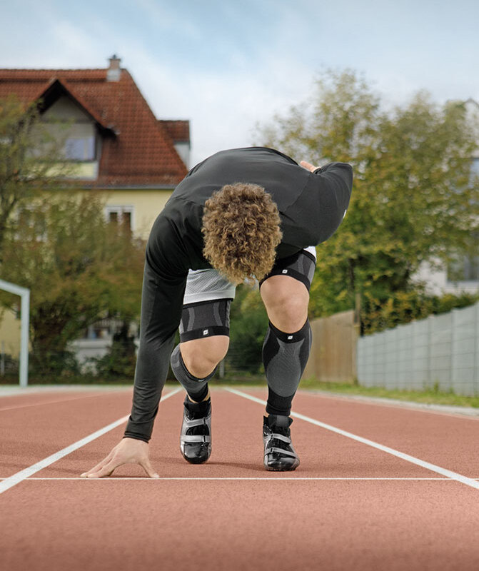 Leichtathlet trainiert auf Laufbahn mit Perform Compression Sleeves
