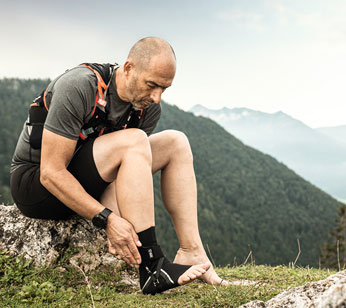 Trailrunner zieht Sprunggelenkbandage FastProtect Malleo an