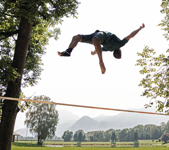 Slackliner trainiert und trägt Sprunggelenkbandage