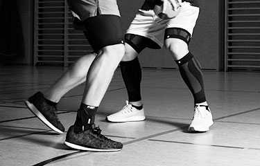 Sportler mit Sprunggelenksbandage und Kompressionsbandagen