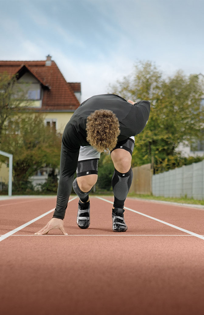 Leichtathlet trainiert auf Laufbahn mit Perform Compression Sleeves
